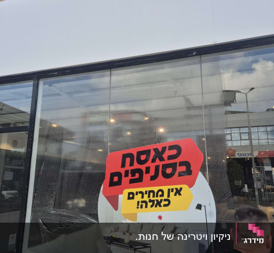 ניקוי חלון עם שלט פרסומי על מבצע